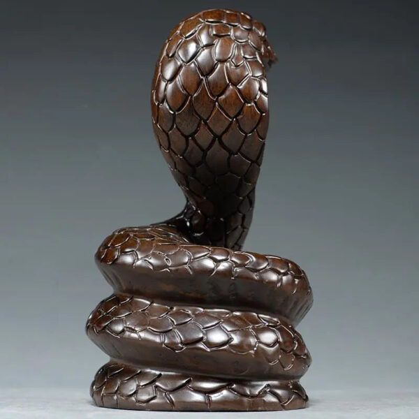 Solid ebony wood carving of the snake among the twelve Chinese zodiac animals (cobra) ornaments. They can attract wealth and are used for home and office decoration as well as feng shui purposes. They are handicraft items made of mahogany.
