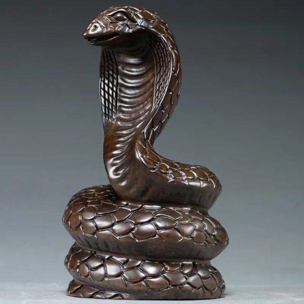 Solid ebony wood carving of the snake among the twelve Chinese zodiac animals (cobra) ornaments. They can attract wealth and are used for home and office decoration as well as feng shui purposes. They are handicraft items made of mahogany.